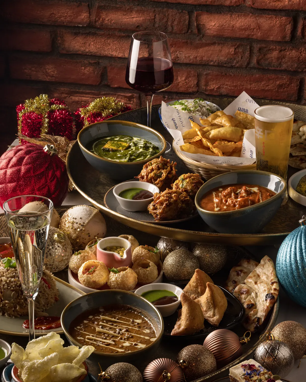 A festive sharing spread at Padharo with baubles, prosecco, samosas, curries and naan