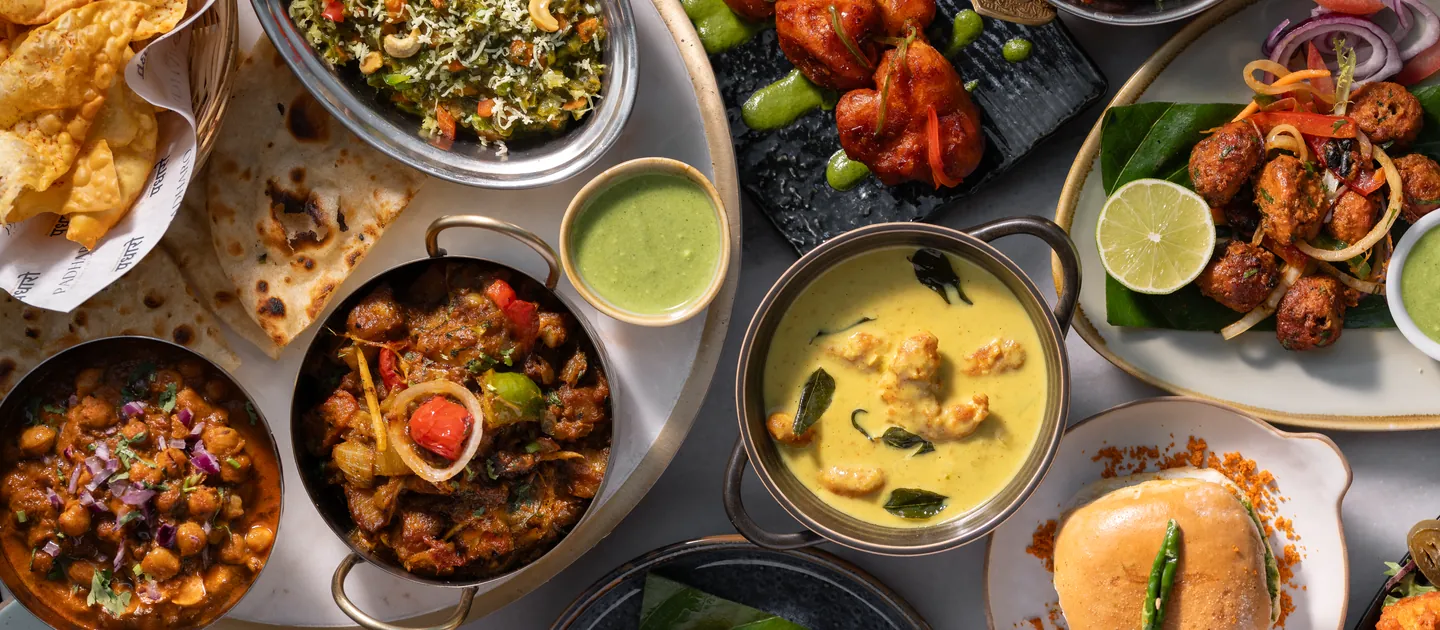 Overhead spread of Padharo dishes: curries, chaats, tandoori skewers and street food