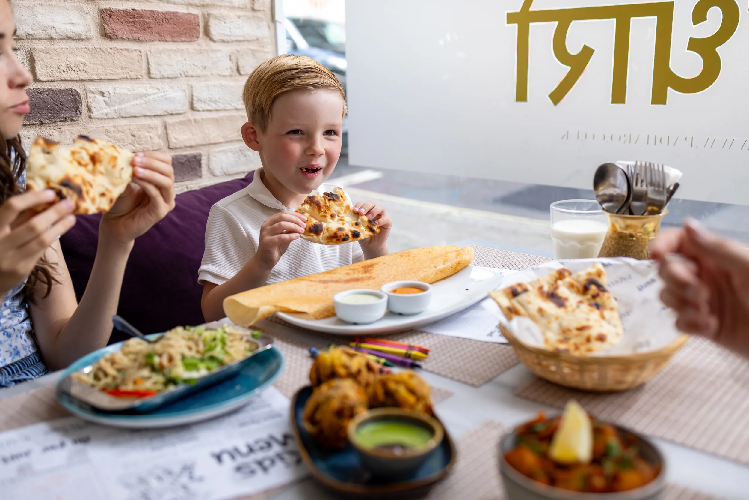 Child enjoying naan bread and dosa at Padharo restaurant