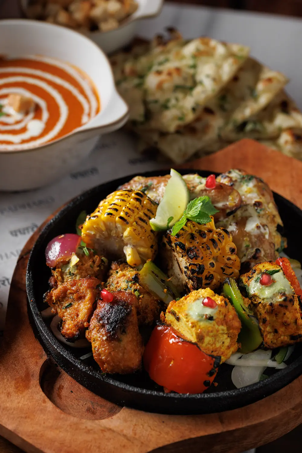 The Padharo Mixed Grill on a sizzler with creamy tomato soup and naan, from the winter menu